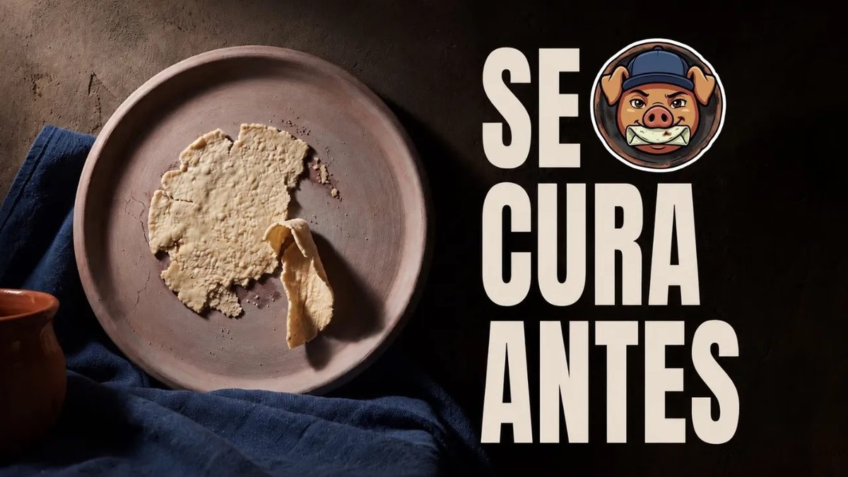 Comal de barro sin vidriar con una tortilla rota y pegada en el centro, sobre un paño azul, junto a un jarro de barro.